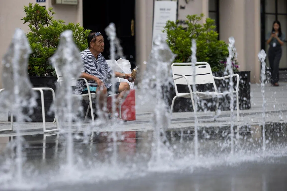 A man cools off near a fountain amid high temperatures in Seoul on Aug 5.