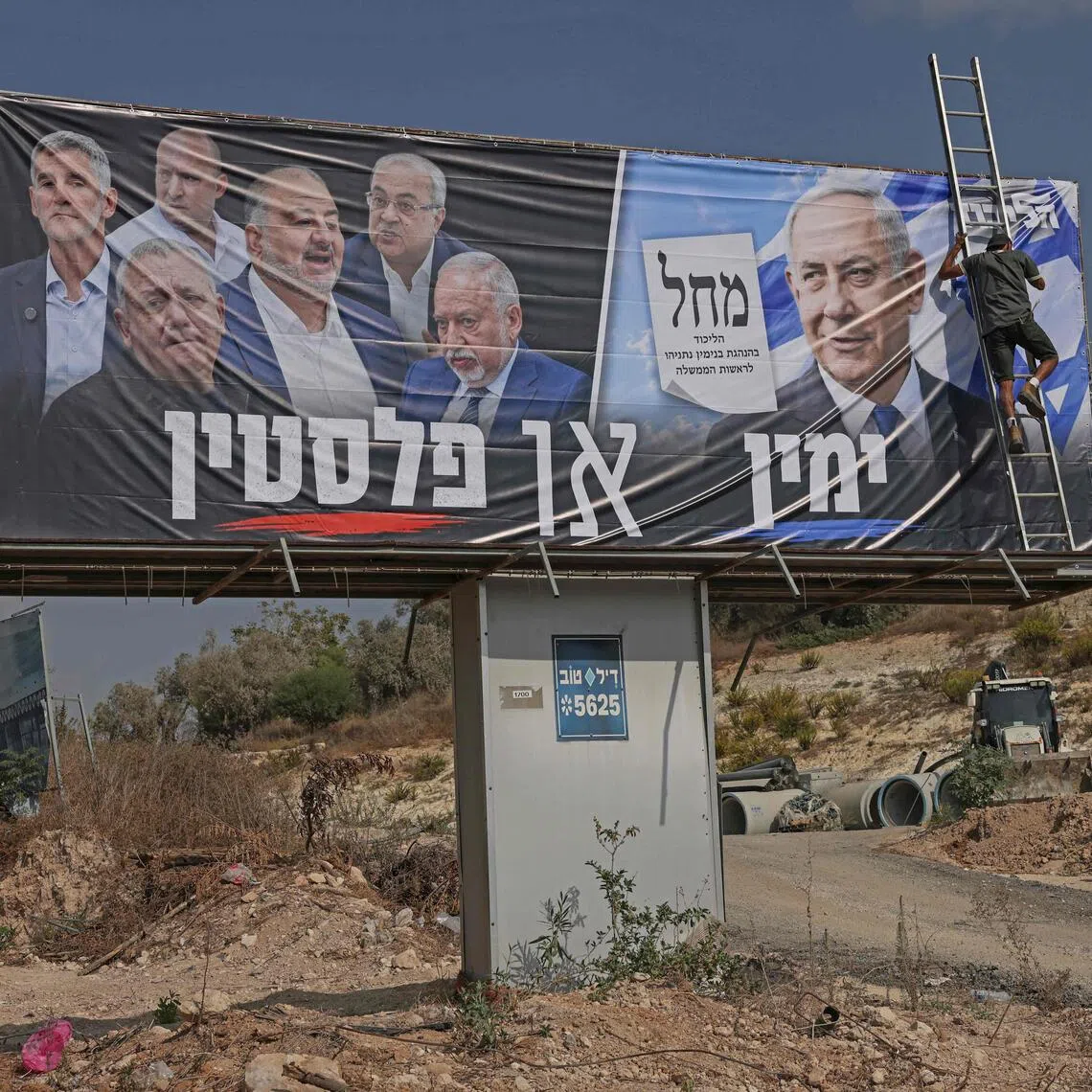 An electoral campaign billboard for Israeli Prime Minister Benjamin Netanyahu’s Likud party, with a Hebrew phrase reading “the Right or Palestine” alongside faces of the members of the opposition.
