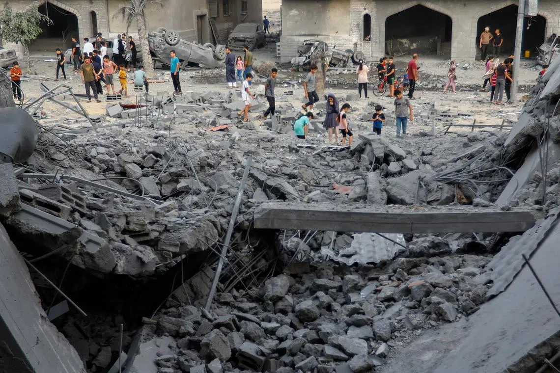 Palestinians inspecting the site of Israeli strikes on a house in Khan Younis in the southern Gaza Strip on Oct 23, 2023. 