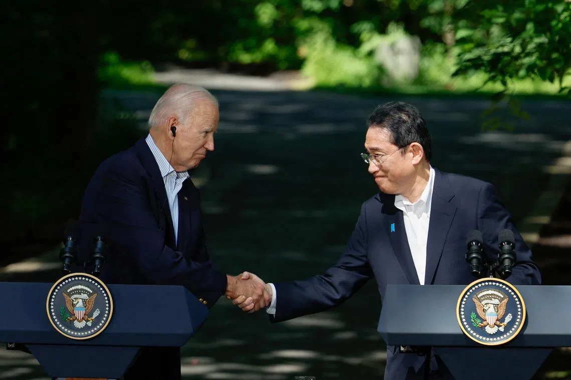 FILE PHOTO: Japanese Prime Minister Fumio Kishida shakes hands with U.S. President Joe Biden during a joint press conference with South Korean President Yoon Suk Yeol (not pictured) during the trilateral summit at Camp David near Thurmont, Maryland, U.S., August 18, 2023. REUTERS/Evelyn Hockstein/File Photo