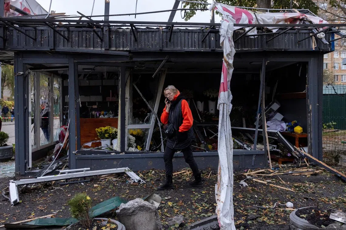 A woman inspects the damage to a shop after a Russian drone strike, amid Russia's attack on Ukraine, in Kyiv, Ukraine October 29, 2024.  REUTERS/Thomas Peter