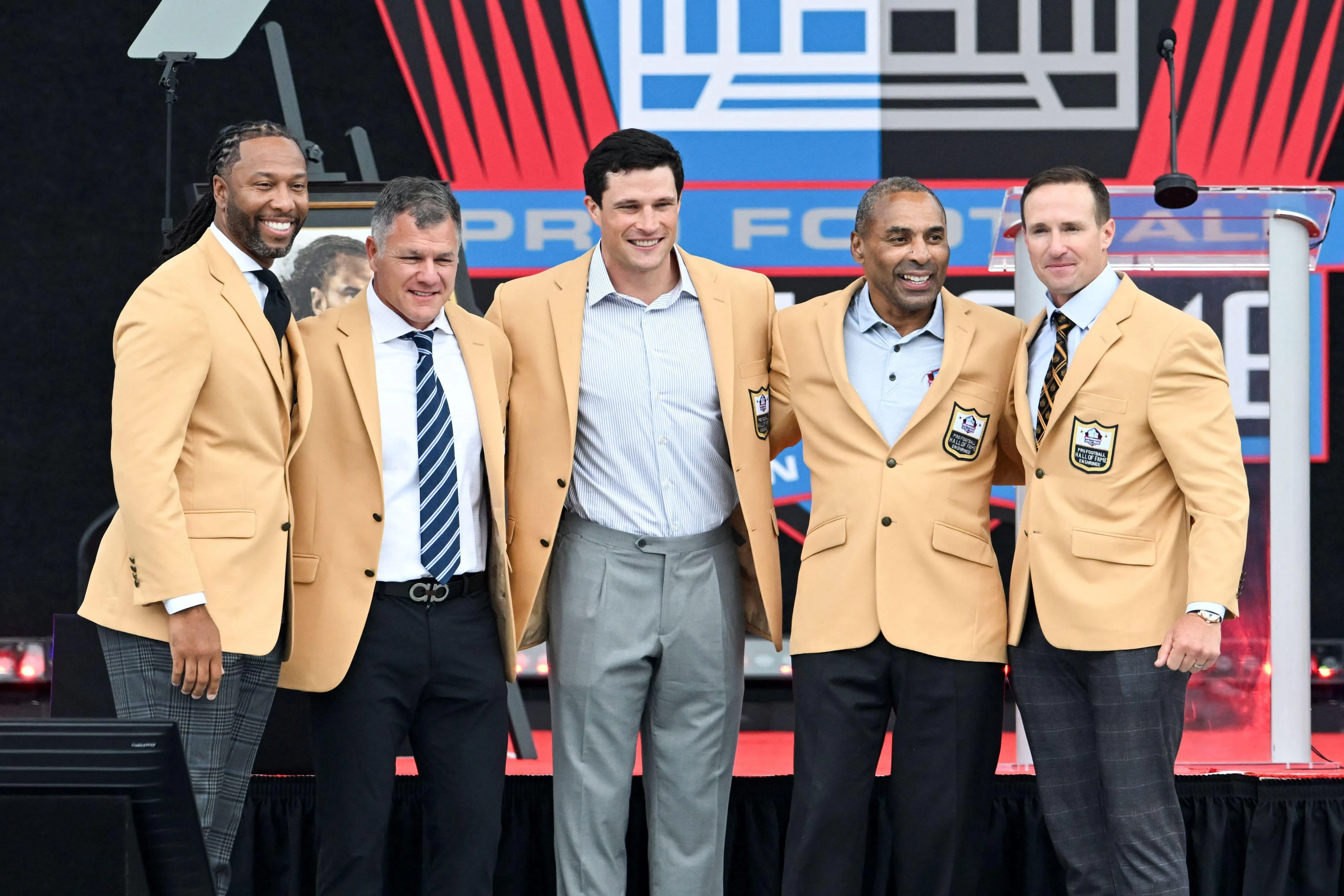 (From left) Larry Fitzgerald, Adam Vinatieri, Luke Kuechly, Roger Craig and Drew Brees posing for photos during the 2026 Pro Football Hall of Fame Enshrinement Ceremony on Aug 8.