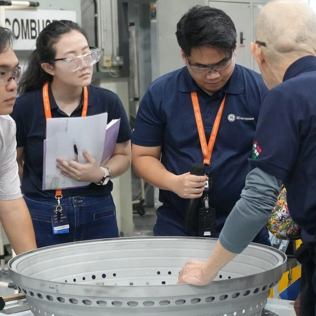 Ms Lim Jia Ying (second from left) collaborates with colleagues at GE Aerospace, where she works on streamlining processes and solving problems to improve safety in engine maintenance and repair.