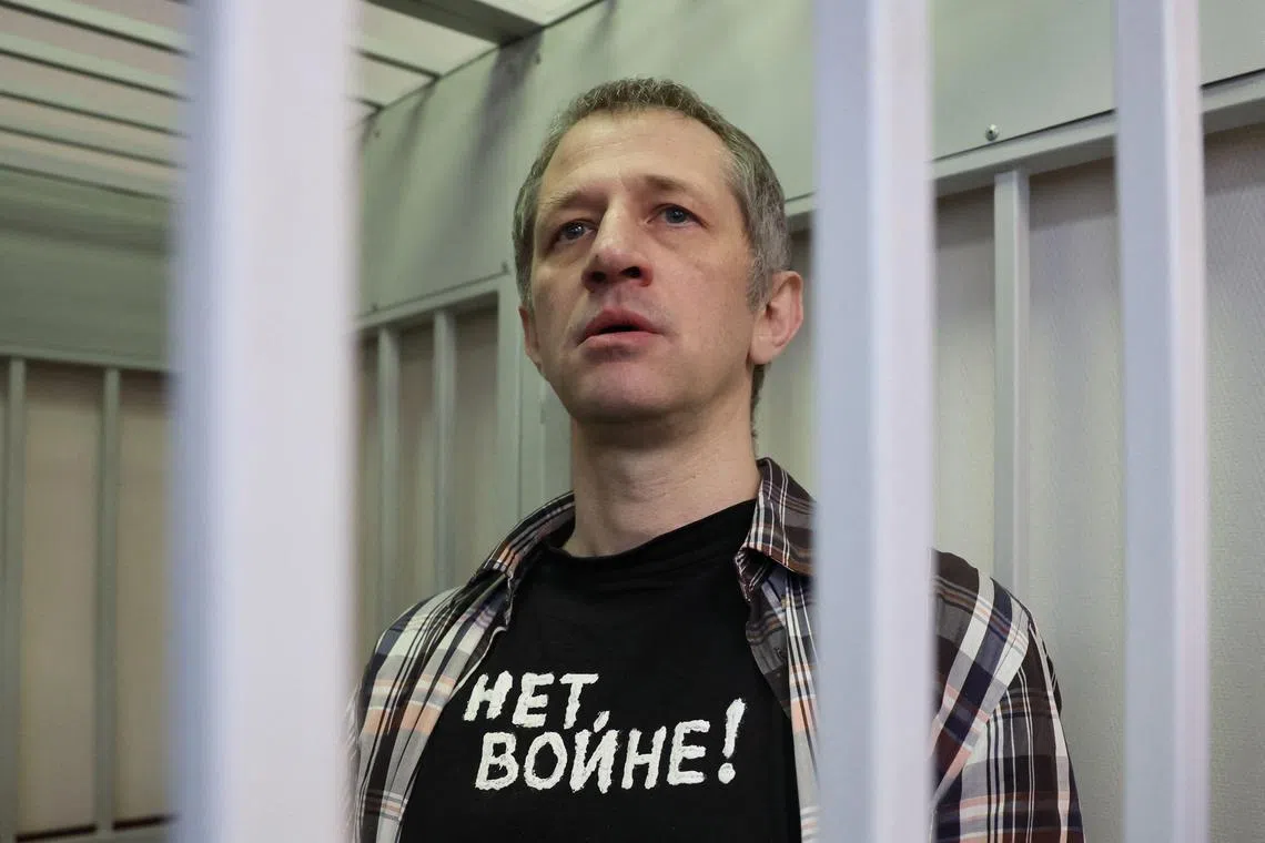 Roman Ivanov wearing a t-shirt that read "no war" inside the defendants' cage after being sentenced to seven years' jail.