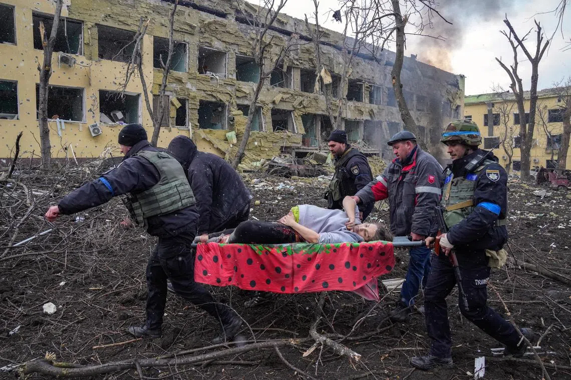 The picture by Ukrainian photojournalist Evgeniy Maloletka of the Associated Press news agency shows rescuers carrying Ms Iryna Kalinina, 32, from the rubble of the hospital in the devastated port city.