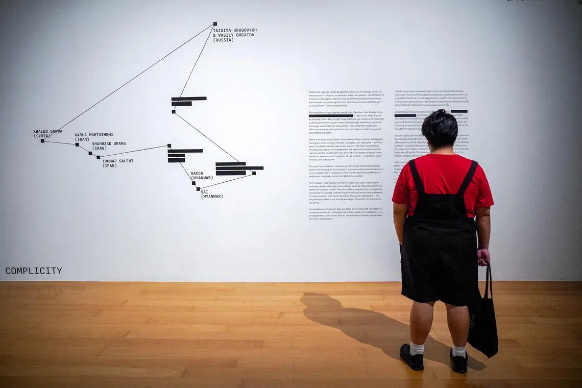 FILE PHOTO: A man reads description with artist names blacked out, following what the Bangkok Arts and Cultural Centre (BACC) said in an email was 'pressure from the Chinese Embassy', at the exhibition titled 'Constellation of Complicity: Visualising the Global Machinery of Authoritarian Solidarity' in Bangkok, Thailand, August 7, 2025. REUTERS/Athit Perawongmetha/File Photo