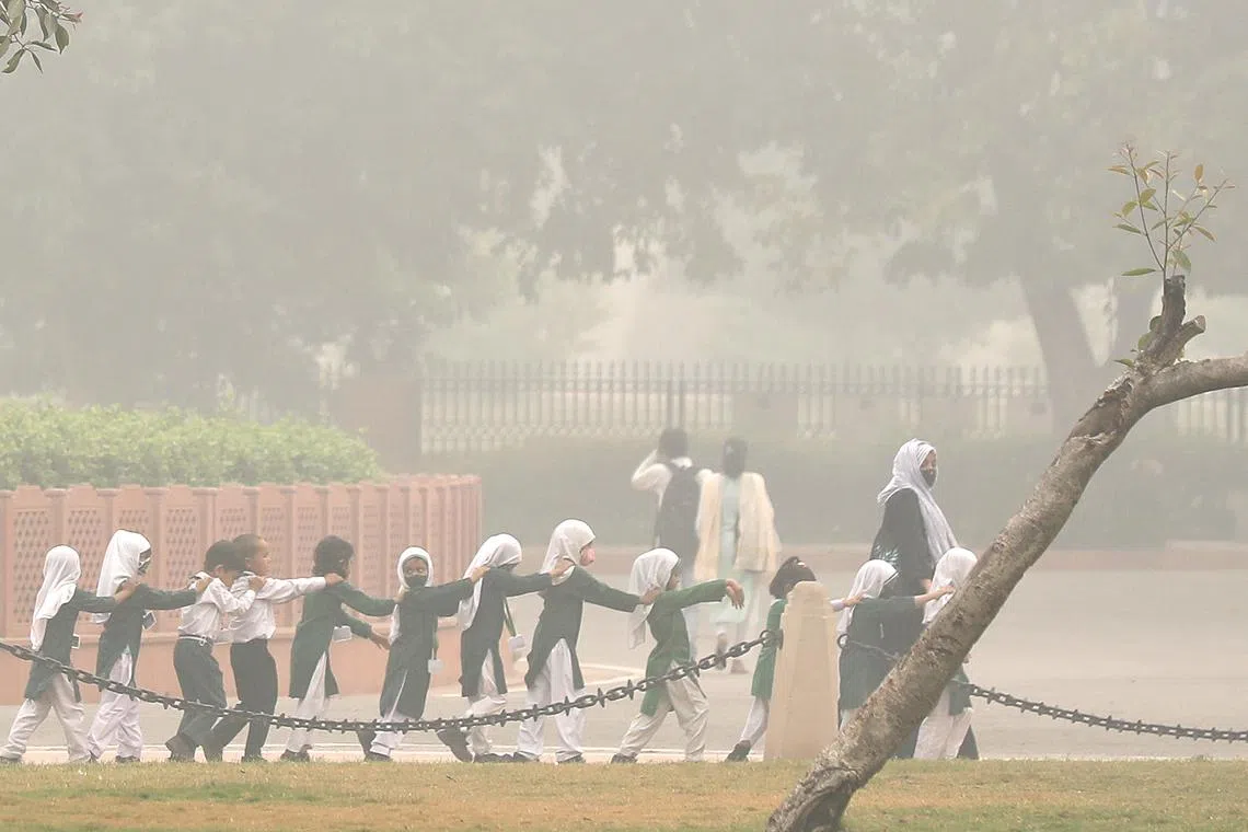 Indian school children wearing face masks are seen as the city is engulfed in heavy smog at India gate, in New Delhi, India, Nov 4 2023. 
