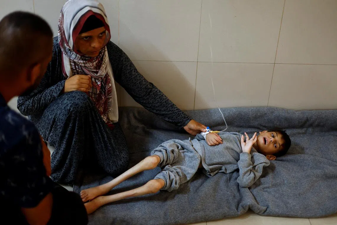 Palestinian mother Ghaneyma Joma sits next to her malnourished son Younis Joma as he receives treatment at Nasser hospital in Khan Younis, in the southern Gaza Strip, July 8, 2024. REUTERS/Mohammed Salem/File Photo