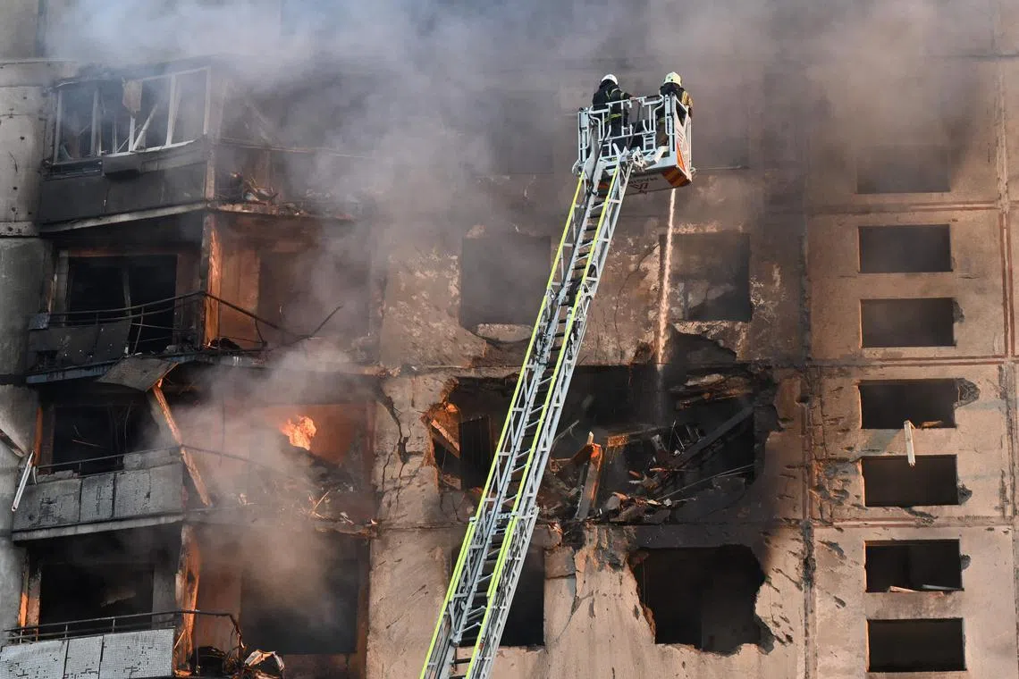 Ukrainian rescuers working to put out a fire at a residential building in Kharkiv, following a Russian missile attack on Sept 15.