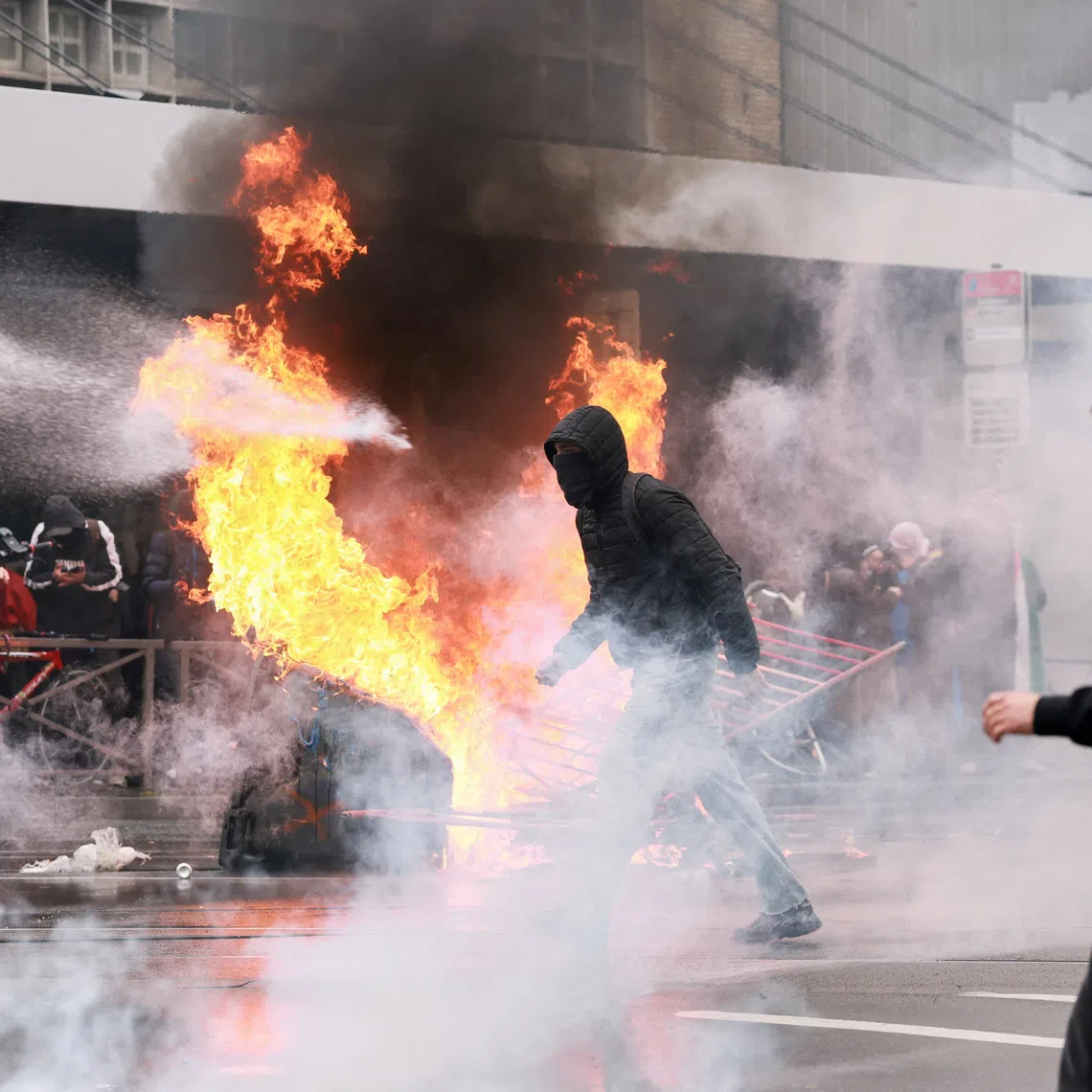 A person is sprayed by a water cannon as protesters, including students, attend a demonstration during a nationwide strike against the Belgian government's austerity measures and budget cuts, in Brussels, Belgium, October 9, 2026. REUTERS/Stephanie Lecocq