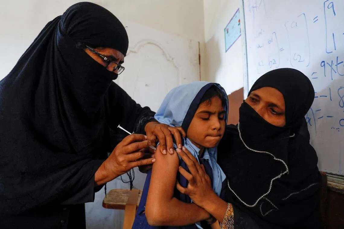 FILE PHOTO: A student reacts as she gets a free anti-typhoid vaccine during the immunisation campaign at a school in Karachi, Pakistan November 20, 2019. REUTERS/Akhtar Soomro/File Photo