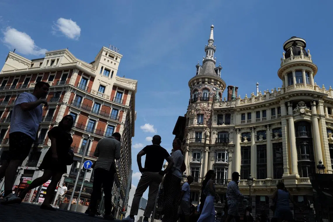 People stand in the shadow in the city centre during a spring heatwave in Madrid, Spain, on May 30.