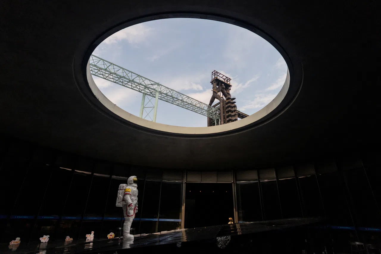 An astronaut figure stands beneath a circular roof opening at the Shou - Wang Tian Gong Beijing Space Exploration Center in Beijing's Shougang Park, China, August 7, 2026. Once highly classified in remote deserts, China's space launches have increasingly been open to public viewing as the country's ambitions accelerate in a race with the United States. Plans include a crewed moon landing by 2030 followed by a crewed mission to Mars. REUTERS/Maxim Shemetov            SEARCH "SHEMETOV CHINA SPACE" FOR THIS STORY. SEARCH "WIDER IMAGE" FOR ALL STORIES.       TPX IMAGES OF THE DAY