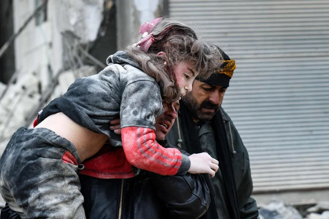 7. Residents carry an injured child from the rubble of a collapsed building following an earthquake in the town of Jandaris, in the countryside of Syria's northwestern city of Afrin in the rebel-held part of Aleppo province, on Feb 6, 2023. 