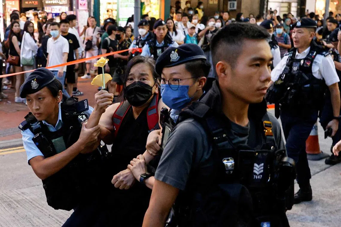 Police detain a woman with paper flowers on the 34th anniversary of the 1989 Beijing's Tiananmen Square crackdown, near where the candlelight vigil is usually held, in Hong Kong, China, June 4.