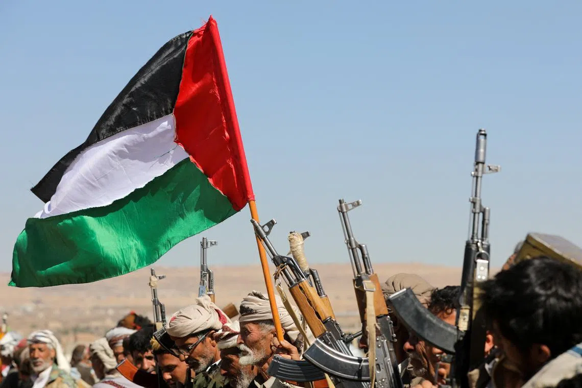 Tribal supporters of Yemen's Houthis waving a Palestinian flag during a protest on recent US-led strikes on Houthi targets, near Sanaa, Yemen, on Jan 14.