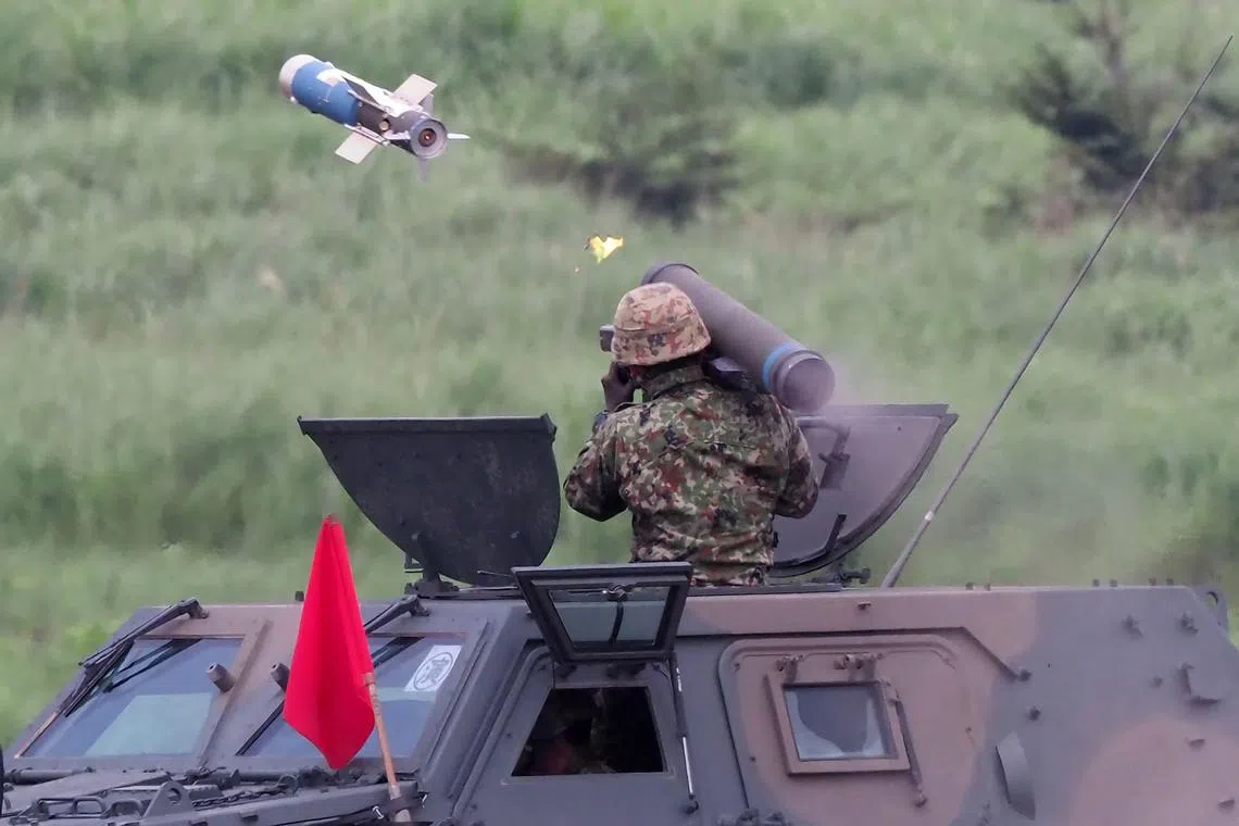 (FILES) This file photo taken on August 22, 2019 shows a soldier firing a Type-01 anti-tank missile from a light armoured vehicle during the Japan Ground Self-Defense Forces' annual live fire exercise at the Higashi-Fuji firing range in Gotemba in Shizuoka prefecture. - Japan announced on December 16, 2022 its biggest defence overhaul in decades, hiking spending, reshaping its military command and acquiring new missiles to tackle the threat from China. (Photo by Toshifumi KITAMURA / AFP)