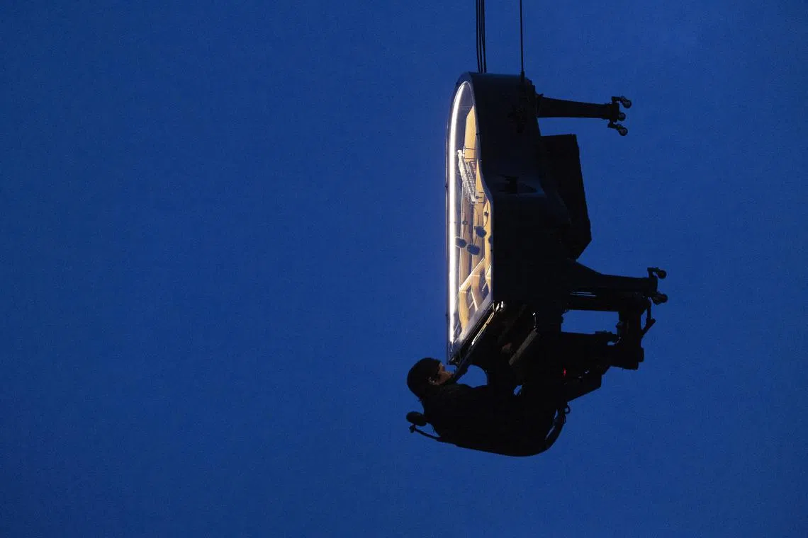 Artist Alain Roche plays a piano concert while hanging from a crane, in Munich, Germany, on Mar 19. Audience of the project 'When The Sun Stands Still' listened to the piano played, mixed with the sound of awakening nature. Over 40 highly sensitive microphones were placed in nature throughout Bavaria and Switzerland for the performance.