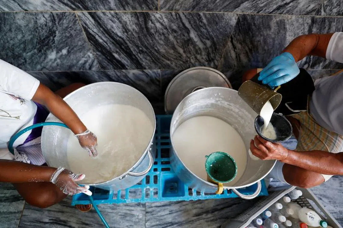 FILE PHOTO: Helpers fill bottles with milk to be distributed among people in need at a soup kitchen run by religious group Quisicuaba that is serving a growing number of Cubans struggling to make ends meet amid economic crisis, in Havana, Cuba January 15, 2024. REUTERS/Yander Zamora/File Photo