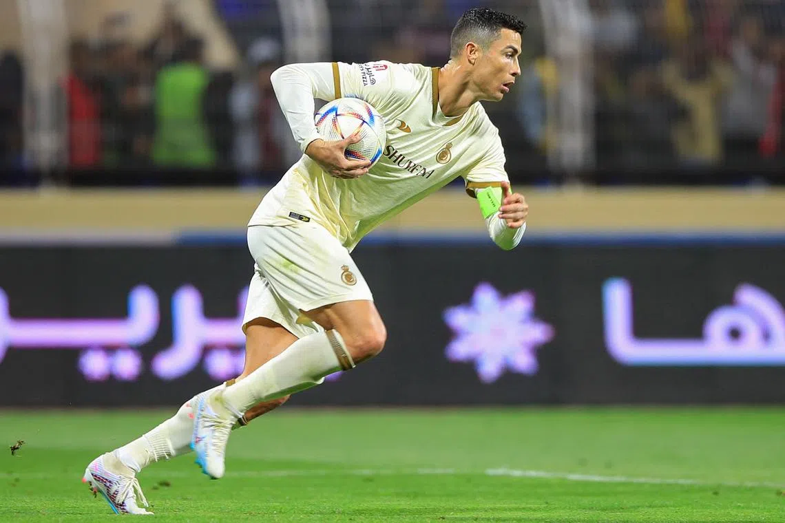 Al Nassr's Cristiano Ronaldo runs with the ball after scoring a penalty during the Saudi Pro League match against Al Fateh on Friday.