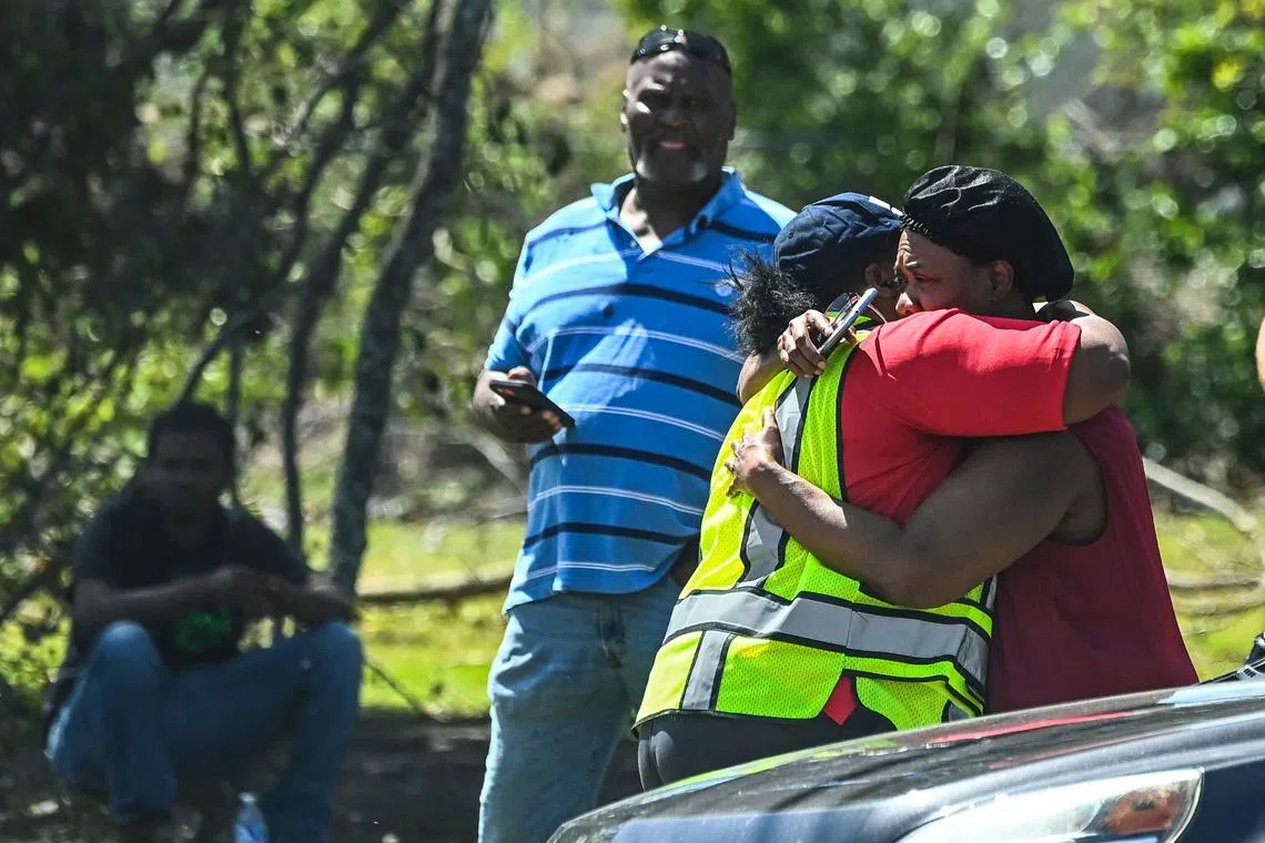 A victim of the devastation hugging a fire worker as her house catches fire in Rolling Fork, Mississippi, after a tornado touched down in the area, on March 26. 
