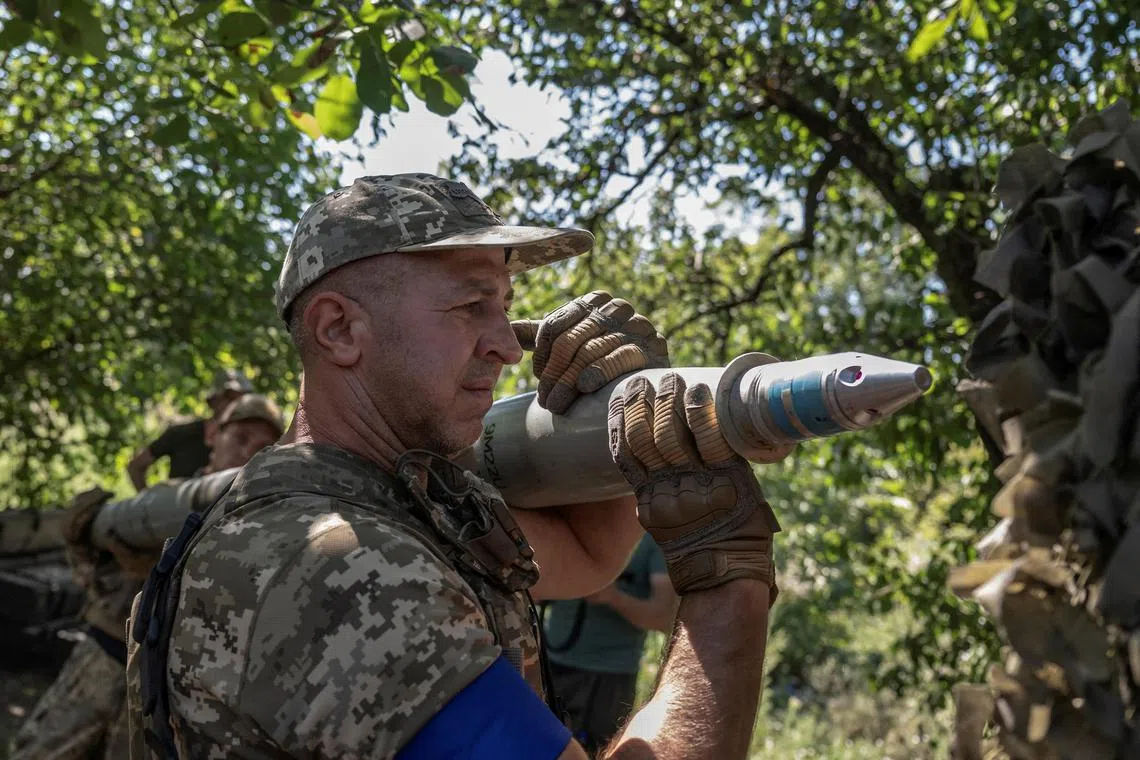 A Ukrainian serviceman prepares a shell for firing at Russian positions in Ukraine's Zaporizhzhia region.