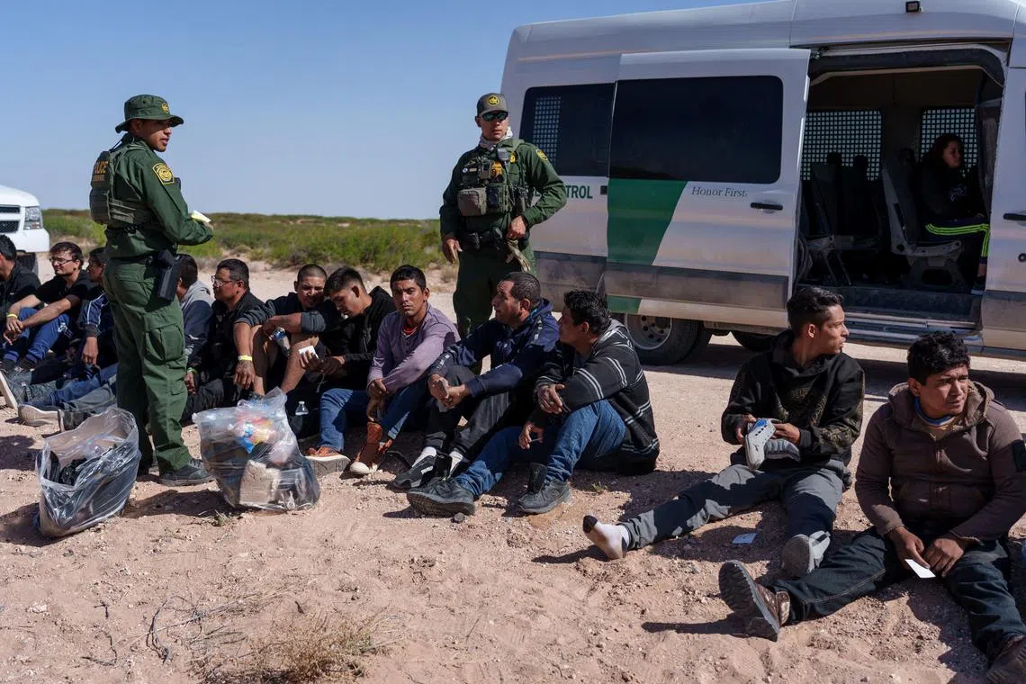 Migrants wait to be processed by US Border Patrol agents in Santa Teresa, New Mexico, after being apprehended trying to cross the border undetected.