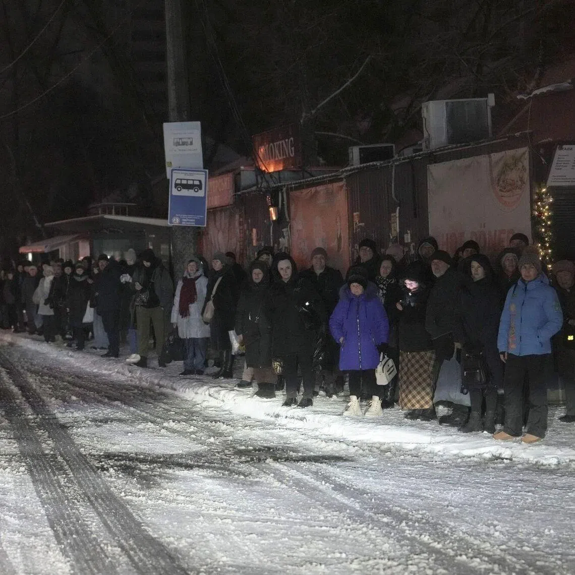 People wait for public transport during a blackout following Russian air strikes in Kyiv, on Jan 9. The city is facing widespread power shortages.