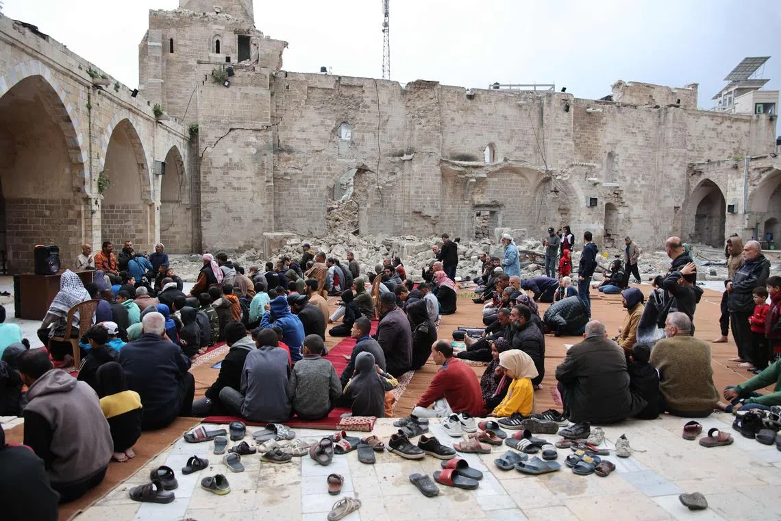 Palestinian worshippers gather in the courtyard of Gaza City's historic Omari Mosque, which has been heavily damaged in Israeli bombardment.