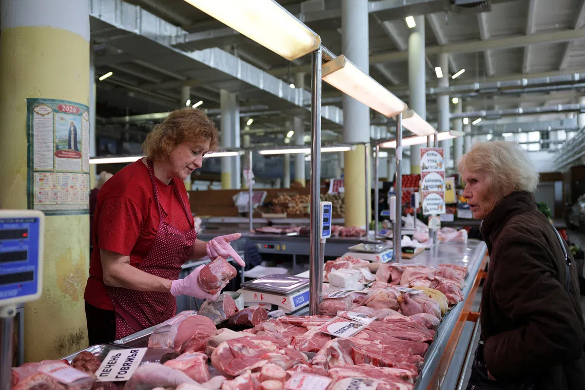 A vendor shows cuts of meat to a customer at a market in Yaroslavl, Russia, September 12, 2026. REUTERS/Anastasia Barashkova