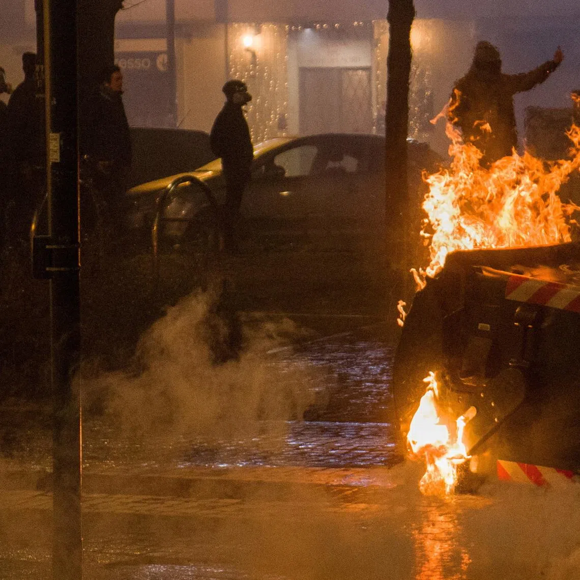 FILE PHOTO:  A demonstrator gestures behind a burning refuse container as demonstrators clash with police following a march in support of Askatasuna, a left-wing social centre that was evicted by authorities in Turin, Italy, January 31, 2026. REUTERS/Michele Lapini/File Photo