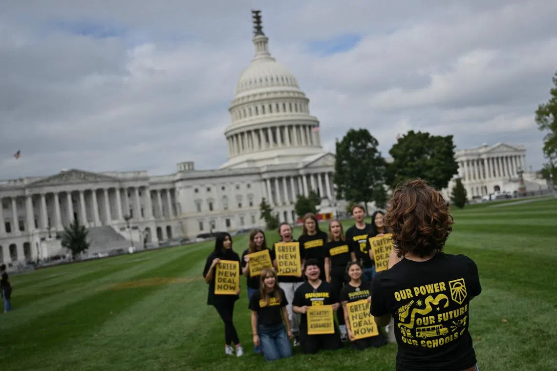 Members of Sunrise Movement who protested at house speaker, Kevin McCarthy office, pose for a photo on the east lawn at the US Capitol.