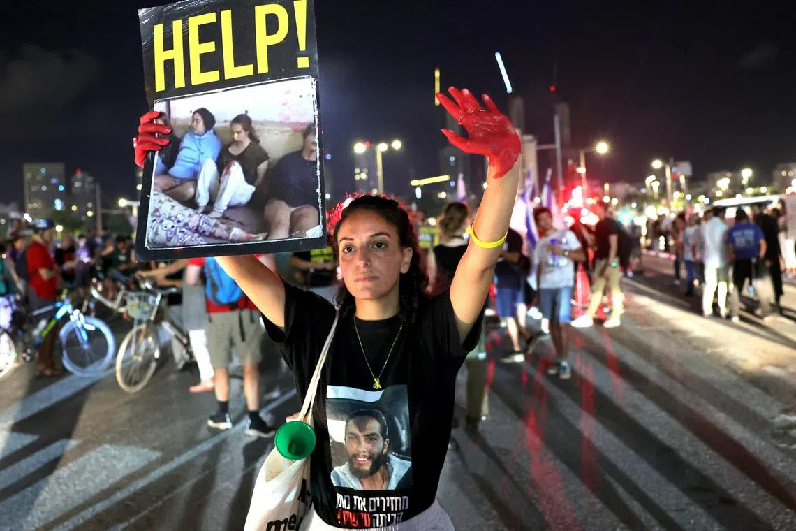 A woman taking part in a Tel Aviv protest against Israeli Prime Minister Netanyahu's government calls for the release of  hostages still held in Gaza by Hamas militants.