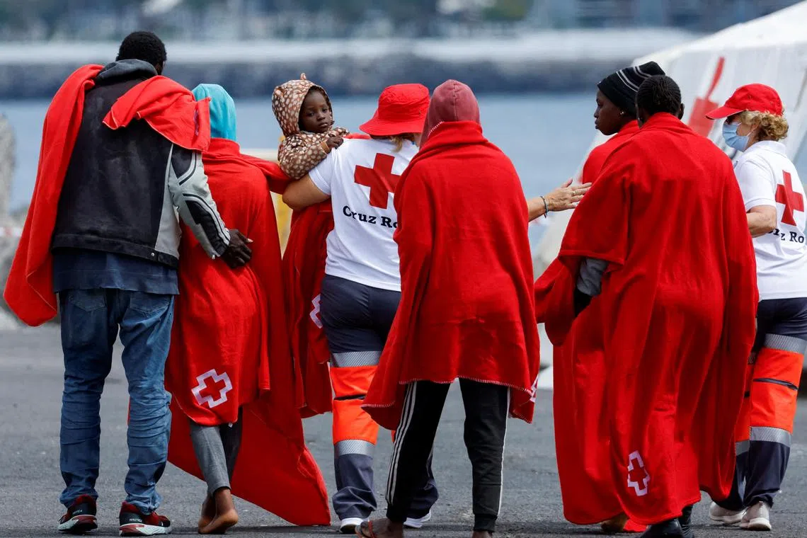 FILE PHOTO: Migrants walk towards a Red Cross tent for treatment after disembarking from a Spanish coast guard vessel at the port of Arguineguin, on the island of Gran Canaria. Spain, June 6, 2024. REUTERS/Borja Suarez/File Photo