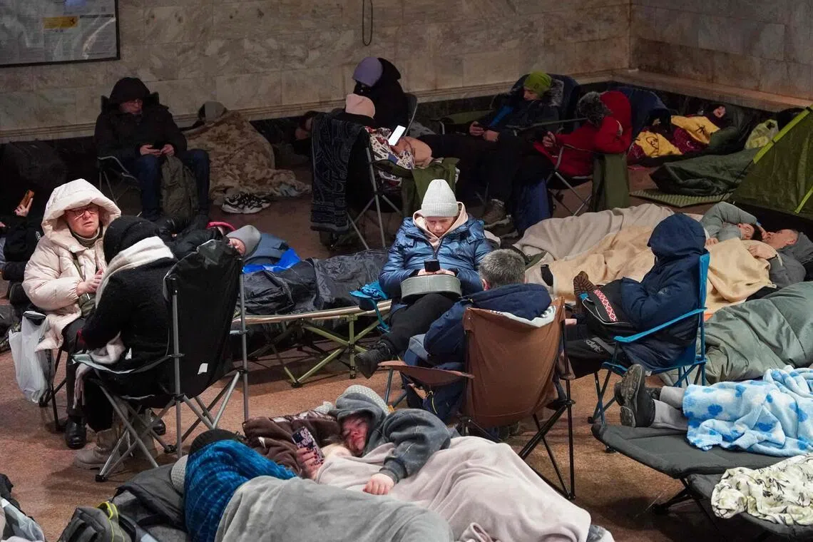 People take shelter at a metro station during a Russian air attack, in Kyiv, early on Feb 3.
