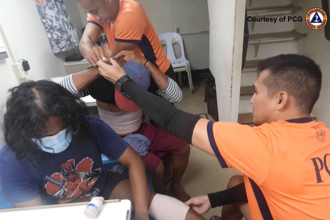 Philippine coast guard personnel attending to injured fishermen after Chinese coast guard ships used water cannon and cut the fishermen's anchor lines near Sabina ​Shoal ​on Dec 12.
