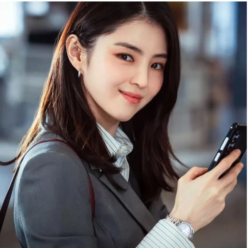 Han So Hee wears the Gael Studded Convertible Kitten-Heel Knee-High Boots (left), and carries the Kerry Top Handle Satchel Bag.