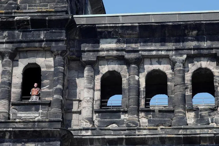 A man dressed as a Roman soldier is seen in one of the windows of Porta Nigra, former Roman city gate, in Trier, Germany.