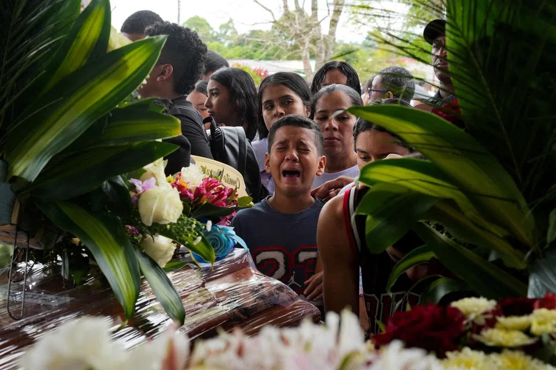 A child mourning in front of caskets during a funeral service for victims of a deadly attack that authorities blamed on a dissident faction of the former FARC guerrilla group, in Cajibio, Colombia, April 28.