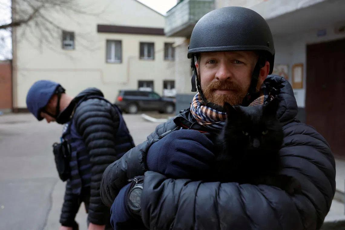 FILE PHOTO: Reuters safety advisor Ryan Evans holds a cat during a news assignment, as Russia's attack on Ukraine continues, during intense shelling in Kramatorsk, Ukraine, December 26, 2022. REUTERS/Clodagh Kilcoyne/File Photo