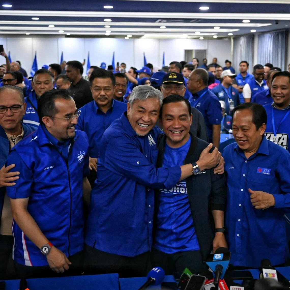 Barisan Nasional chairman Zahid Hamidi (third from left) hugging caretaker menteri besar Onn Hafiz Ghazi as the coalition takes early lead in the Johor state election.