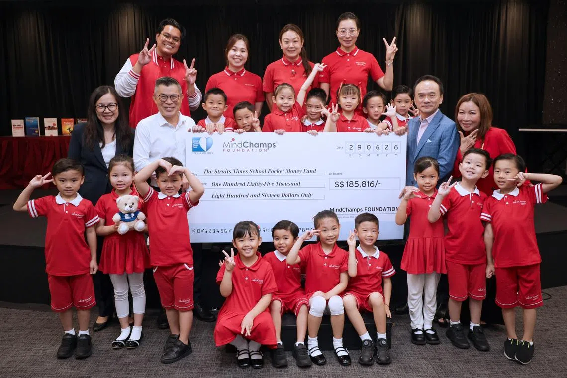 ST editor Jaime Ho (middle row, second from left) receiving the mock cheque from MindChamps founder David Chiem.