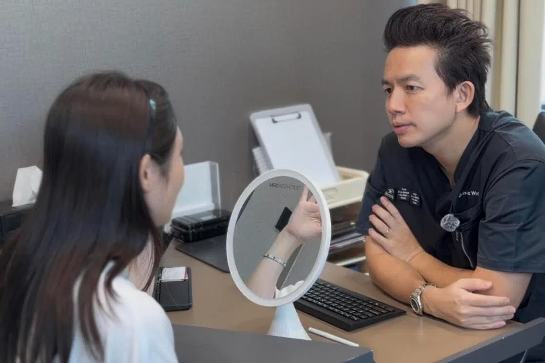 Dr Isaac Wong from Artisan clinic consulting with a female patient 