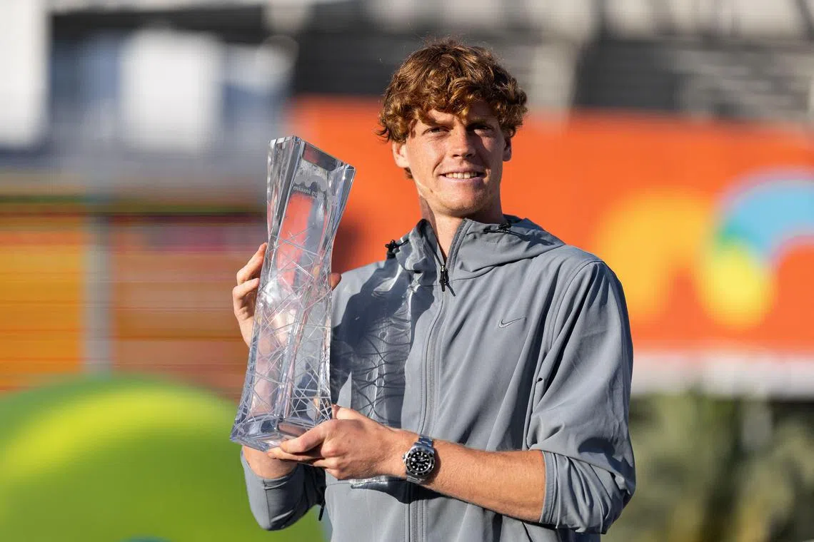 Jannik Sinner posing with the Miami Open trophy at Hard Rock Stadium.