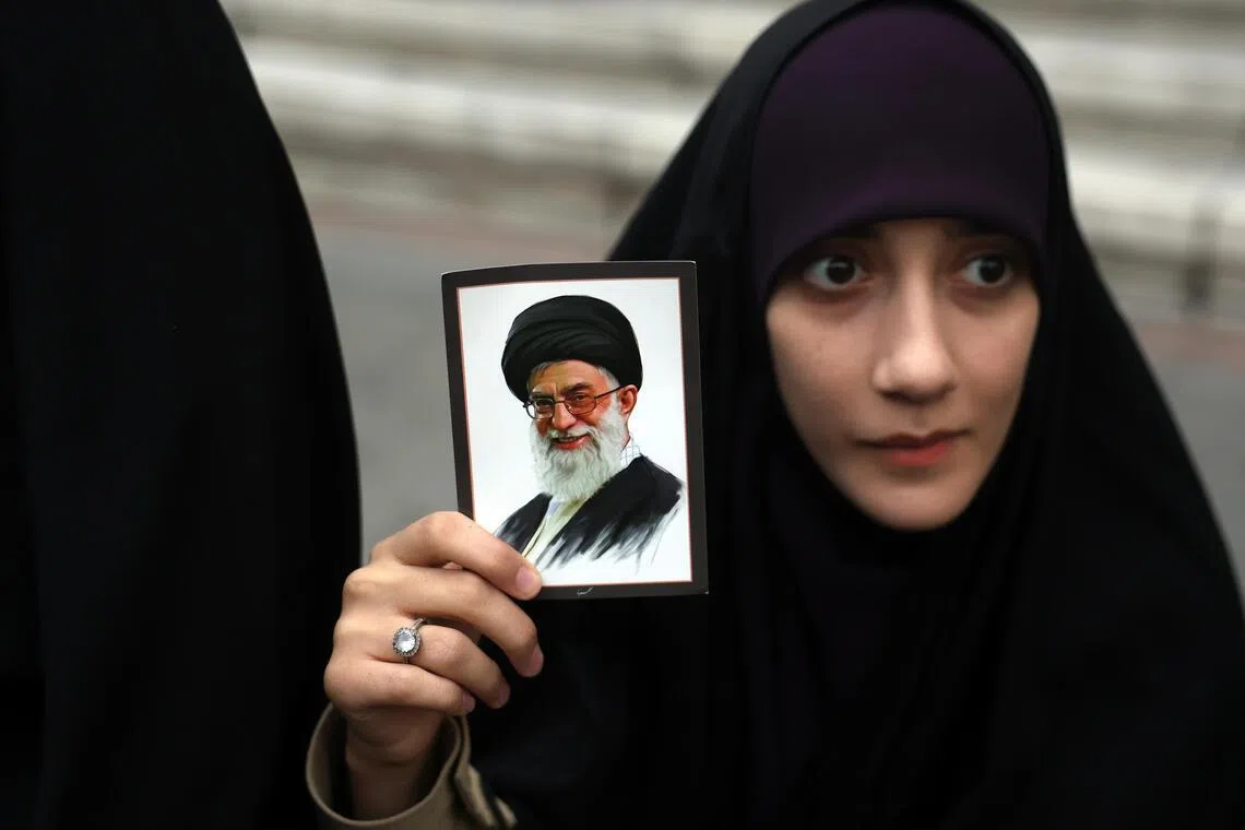 An Iranian woman holding a picture of Ayatollah Ali Khamenei, Iran's supreme leader, during anti-US and Israeli protests in Tehran on Feb 28.