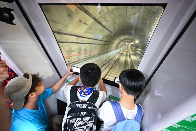 Ten-year-old Leroy Lim (centre) woke up at 4.43am to catch the first train arriving at Keppel station.