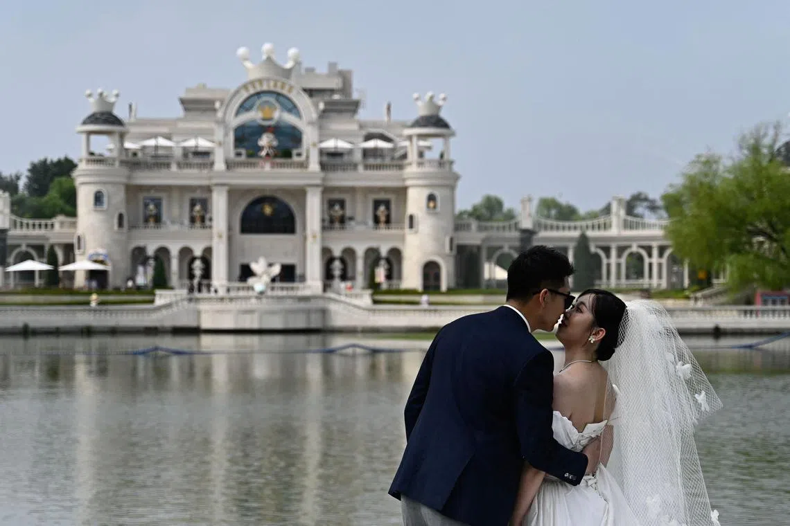 A couple pose for wedding pictures at Chaoyang Park in Beijing on July 21.
