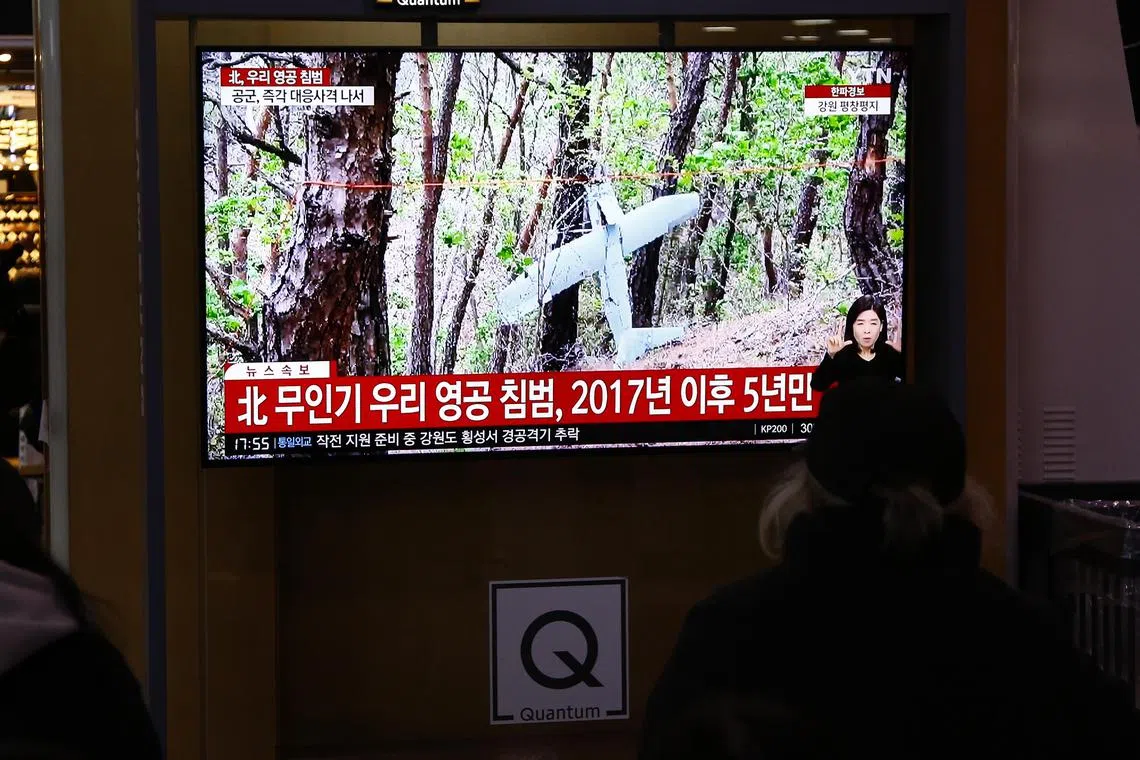 People watching a news programme in Seoul, after multiple North Korean drones reportedly invaded South Korean airspace, on Dec 26, 2022.