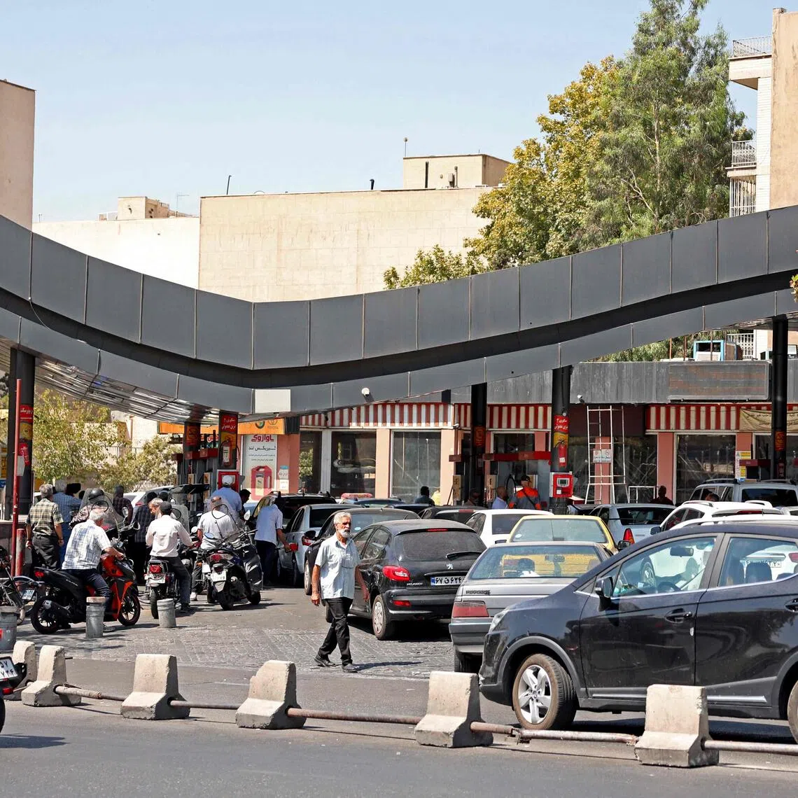 Drivers queue at a petrol station to refuel in Tehran, on Aug 25.