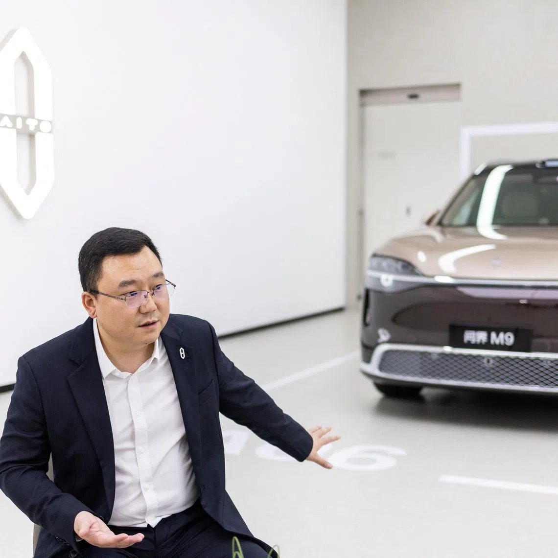 AITO Chairman John Zhang speaks next to a newly presented M9 SUV model.